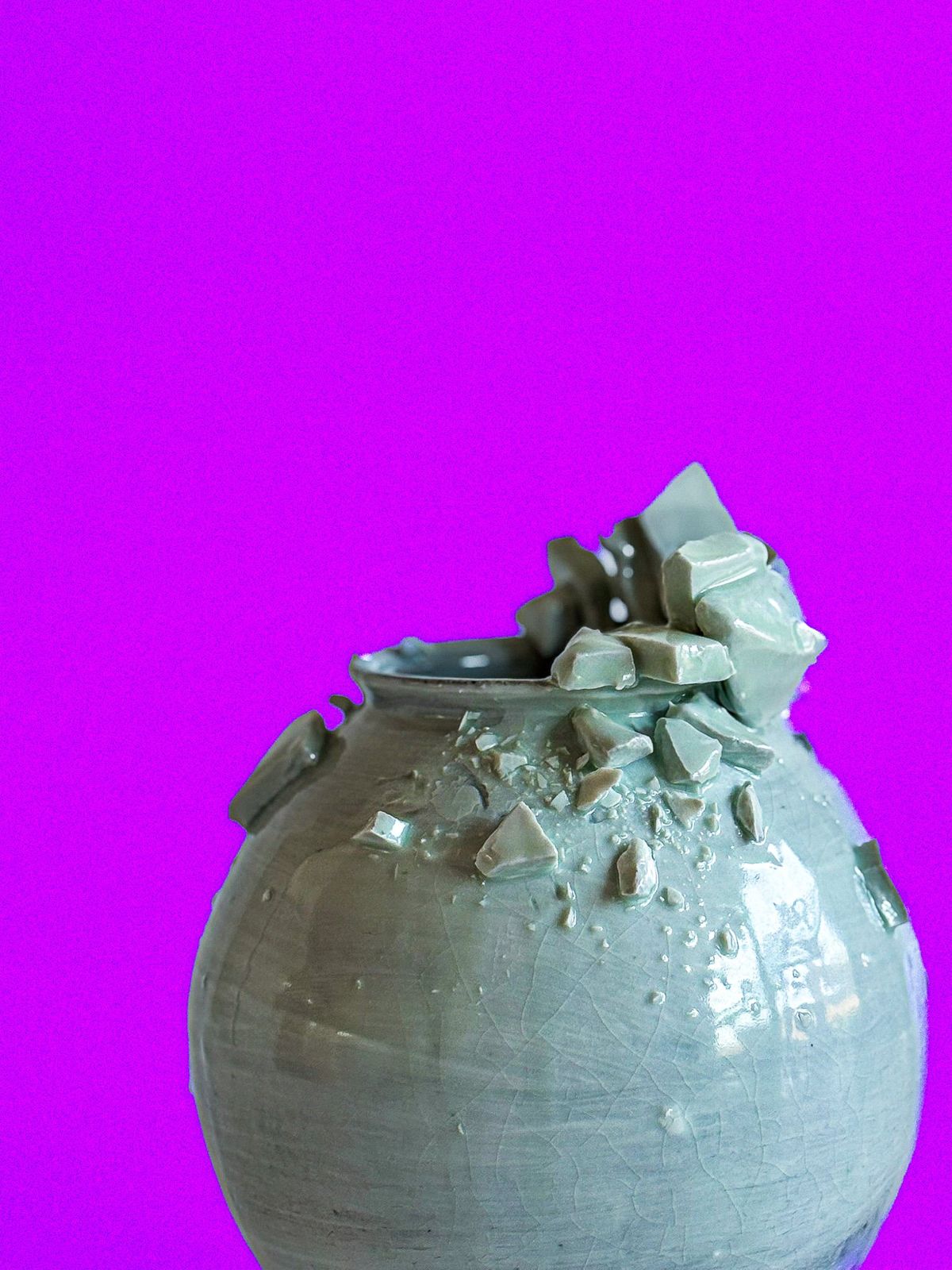 Celadon jar encrusted with porcelain shards against a magenta backdrop