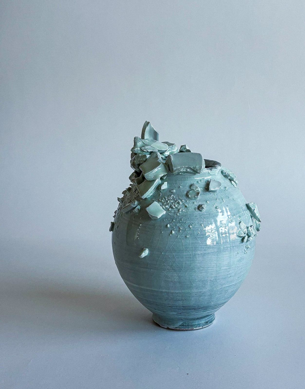 Celadon jar with porcelain shards gathered at the rim