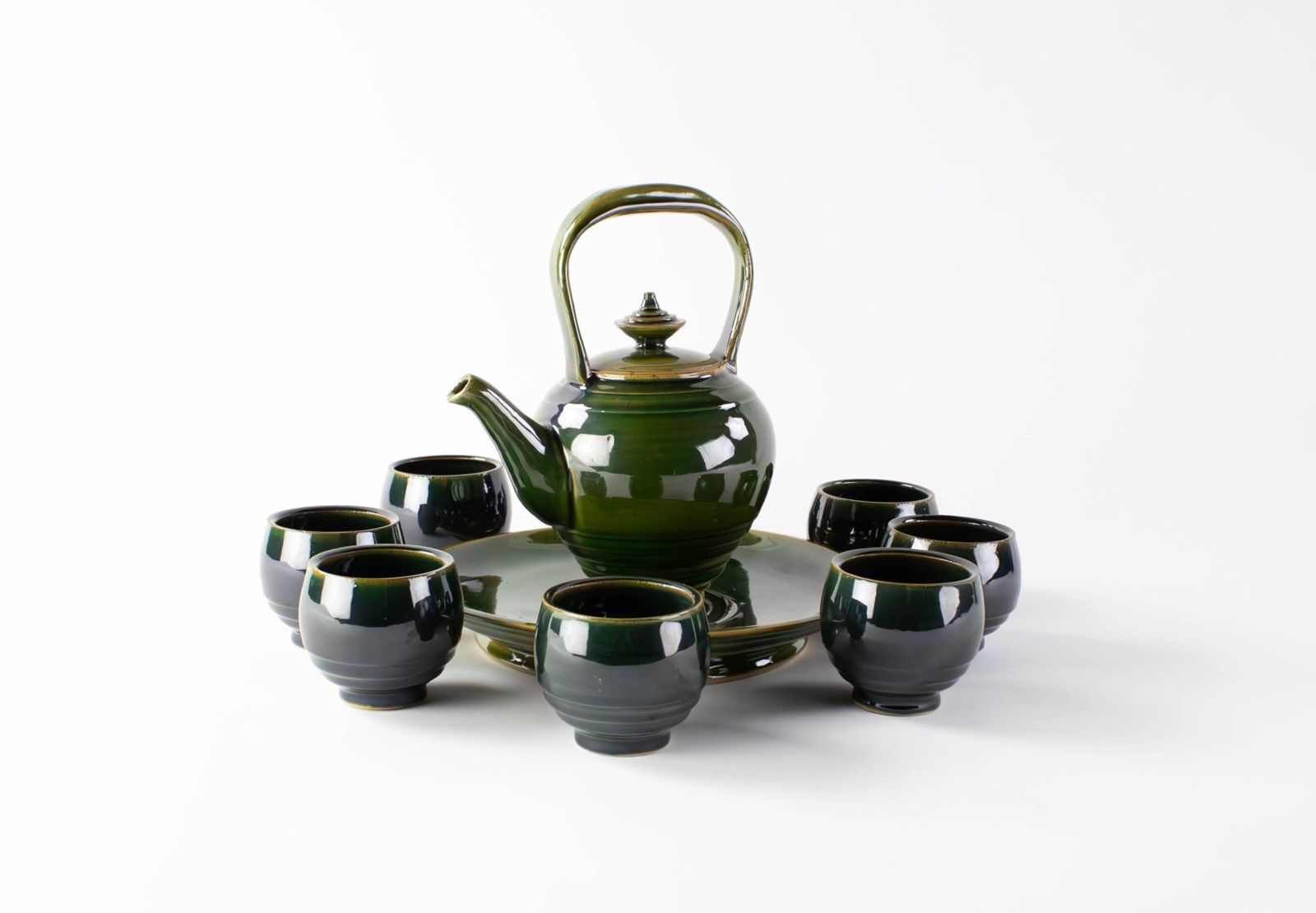Green porcelain teapot with a tray and seven cups