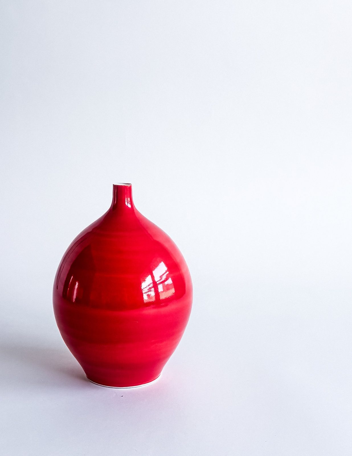 Glossy red porcelain bottle vase with a narrow neck